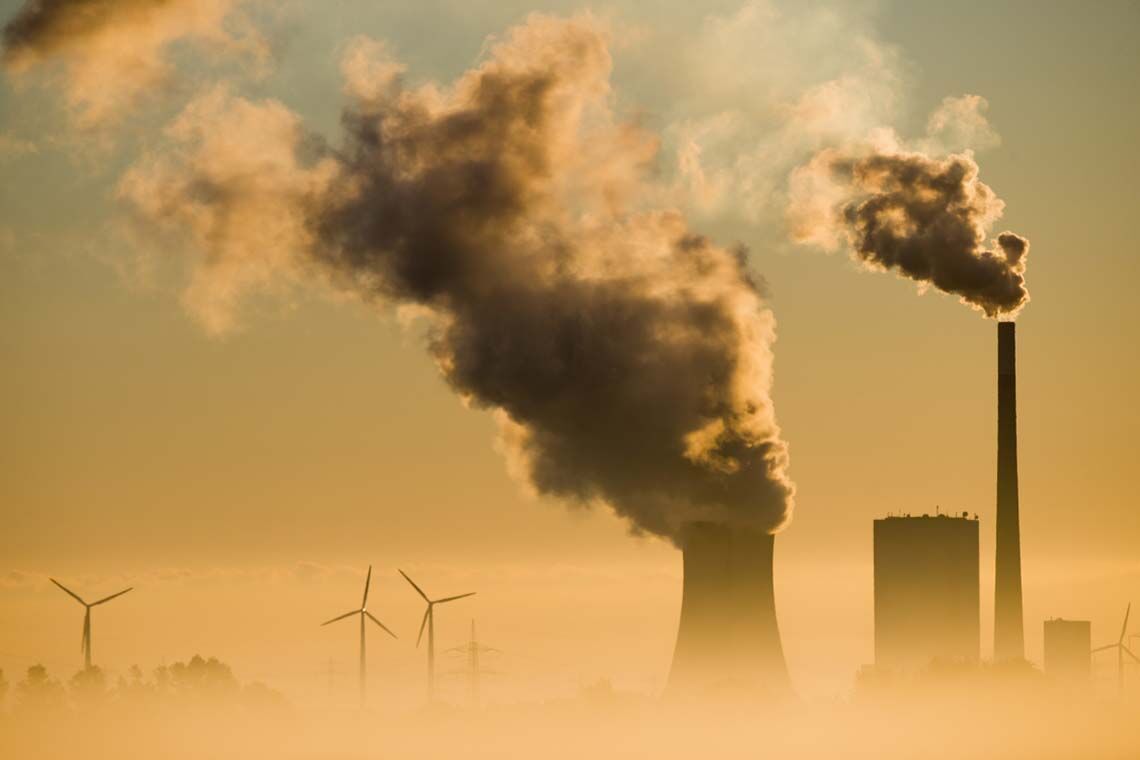 Windräder neben dem Kohlekraftwerk Mehrum in Niedersachsen: Jeder Euro, der in erneuerbare Energien fließt, trägt dazu bei, die Kosten des Klimawandels zu verringern.