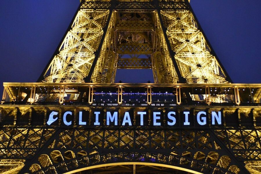 Eifelturm bei Nacht mit Aufschift "Climatesign": Fast 200 Staaten feierten 2015 auf dem Gipfel in Paris einen Durchbruch für den Klimaschutz. Doch sichtbare Zeichen haben seither nur wenige Länder gesetzt.