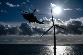Hubschrauber in einem deutschen Offshore-Windpark: Industrie und Politik suchen Wege, um den Ausbau der Windkraft auf See möglichst effizient zu gestalten.