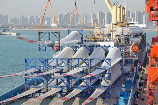 Rotorblätter und Türme von Offshore-Windrädern liegen in einem chinesischen Hafen zur Verschiffung bereit. Fast jedes zweite Offshore-Windrad weltweit steht in China.