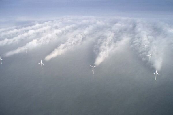 Offshore-Windpark aus der Luft: Wolken hinter den Windrädern bieten ein faszinierendes Schauspiel.