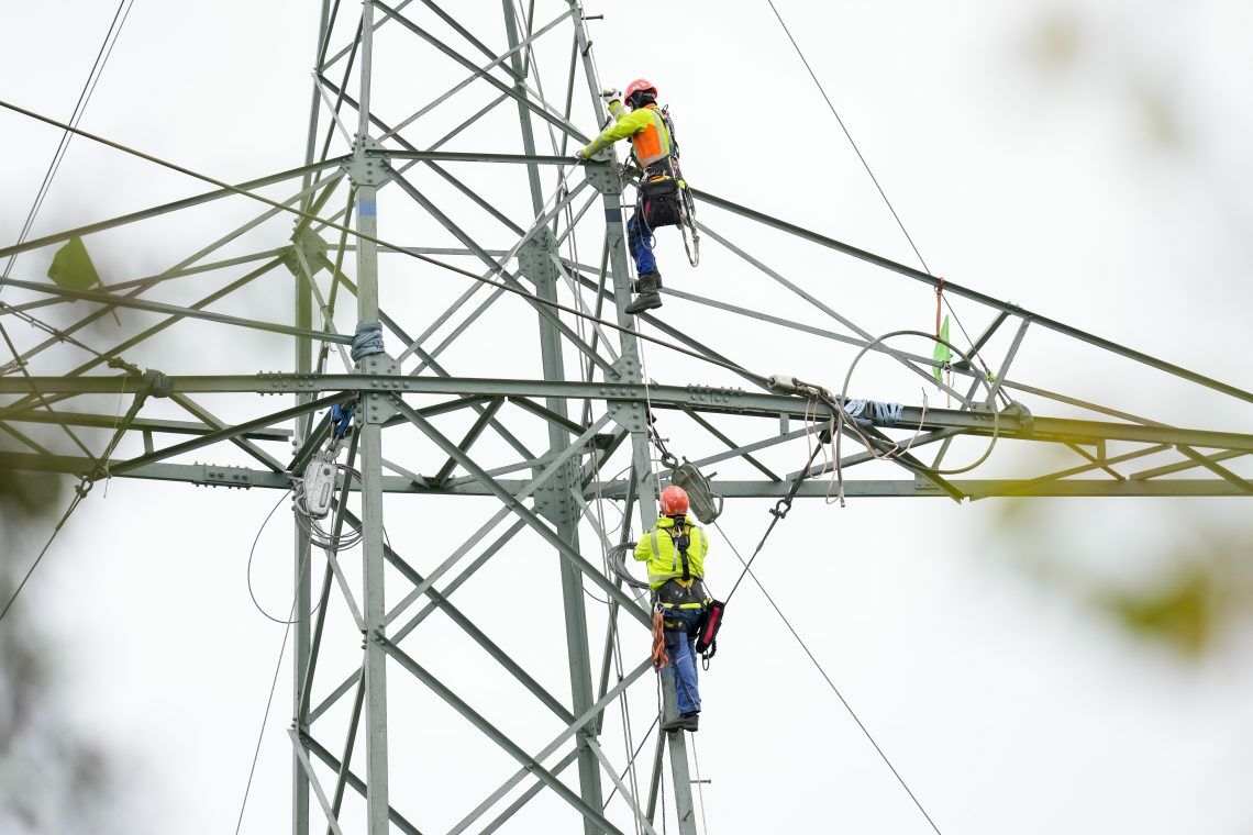 Techniker arbeiten an einem Strommast: Der flächendeckende Ausbau von Smart Metern soll das Stromnetz entlasten und Verbrauchern Sparmöglichkeiten verschaffen.