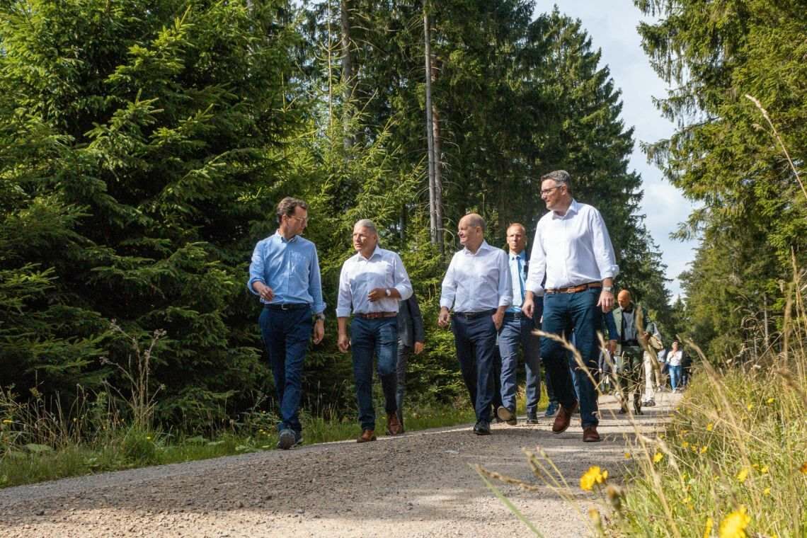 Besuch im Bürgerwindpark Simmerath: Bundeskanzler Olaf Scholz und NRW-Ministerpräsident Hendrik Wüst lassen sich von Bürgermeister Bernd Goffarth den Windpark zeigen.