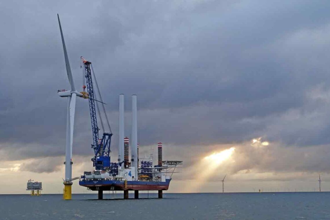 Ein Installationsschiff, auch Arbeits- oder Errichterschiff genannt. installiert einen Windradflügel im britischen Offshore-Windpark Burbo Bank.