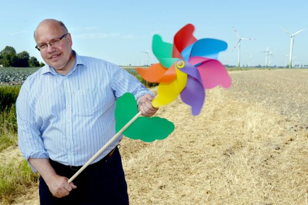 Peter Altmaier posiert mit einem Kinder-Windrad in einem Windpark. Als Umwelt-, Kanzleramts- und Wirtschaftsminister prägt er seit Jahren die Energiewende. Seine Bilanz ist mager.