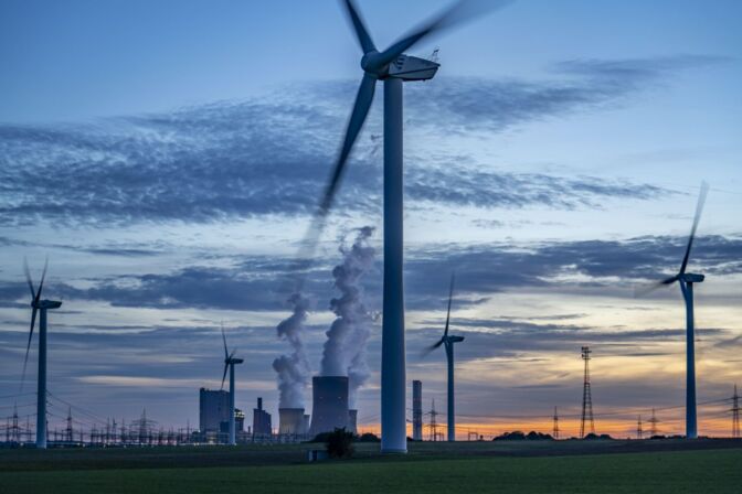Windräder vor dem Braunkohlekraftwerk Niederaußem in NRW: Zwei zum Jahreswechsel bereits stillgelegte Blöcke wurden im Juni wieder hochgefahren, um Gaskraftwerke zu ersetzen und den Strompreis zu dämpfen.
