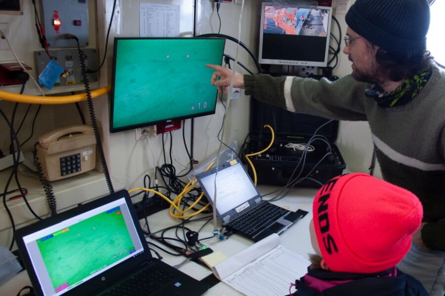 Videoüberwachung im Trockenlabor: Die Forscher diskutieren über die Bilder, die die verschiedenen Messgeräte der „Heincke“ vom Meeresboden nach oben senden.