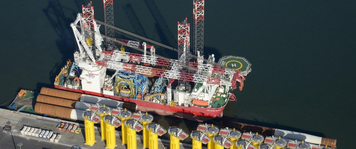 Die „Seajacks Scylla“, das weltweit größte Spezialschiff der Offshore-Windenergie, lädt Fundamente am Kai von Cuxhaven.