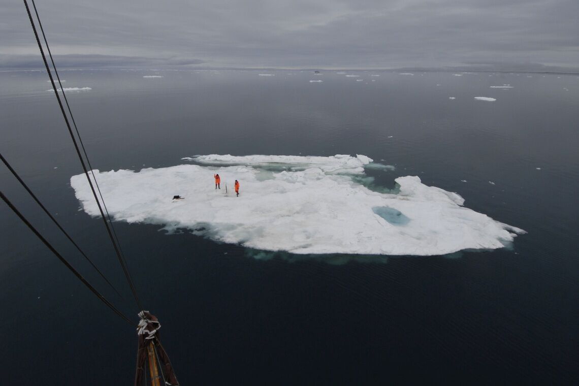 Luftbild vom Mast der Dagmar Aaen auf eine Eisscholle, auf der der deutsche Klimaforscher Dirk Notz einen Eisbohrkern zieht.