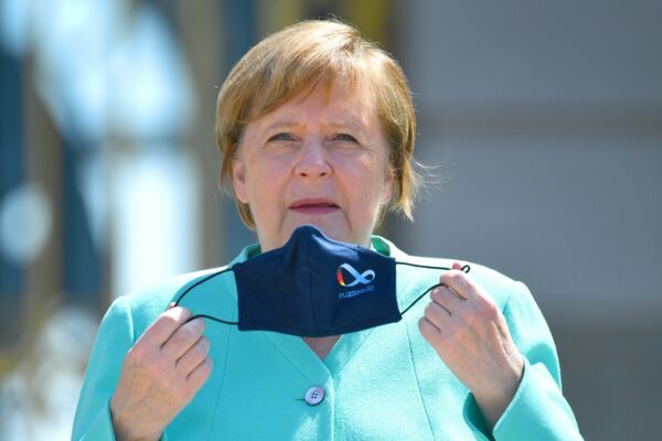 Angela Merkel setzt sich eine Maske mit dem Logo der deutschen EU-Ratspräsidentschaft 2020 auf. Die Erwartungen an die Klima- und Energiepolitik der Kanzlerin sind hoch.