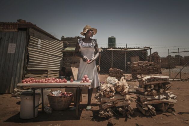 Eine Frau verkauft Feuerholz und Gemüse auf einem Markt in Harare/Simbabwe. Frauen sind von den Folgen des Klimawandels stärker betroffen als Männer.