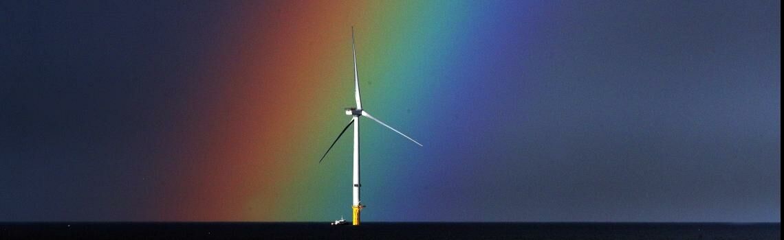 Offshore-Windrad vor spektakulärem Regenbogen, fotografiert vor der Küste von Blyth, Northumberland.