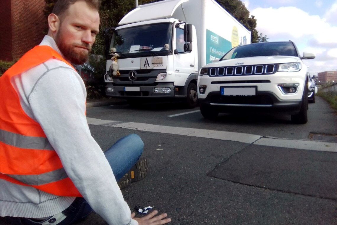 Theodor Schnarr von der Letzten Generation hat sich an eine Straße geklebt, um den Verkehr zu stoppen.
