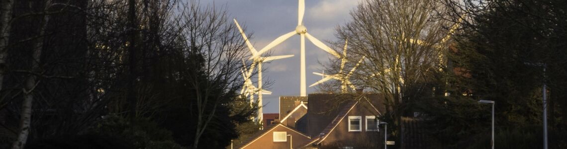 Windräder am Rande einer Wohnsiedlung: Eine neue Langzeitstudie bestätigt, dass der Infraschall der Anlagen keine gesundheitlichen Probleme verursacht. Wenn sich jemand dennoch davor fürchtet, kann das allerdings echten Stress auslösen.