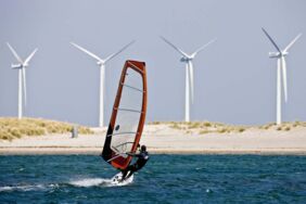Surfer vor Windrädern an der dänischen Küste: Das Land erzeugt 43 Prozent seines Strom aus der Windenergie.