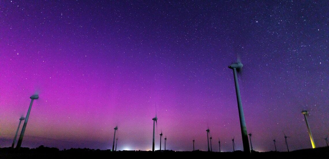 Polarlichter über einem Windpark in Ostfriesland 2024: Die Energiewende läuft viel besser als allgemein angenommen.