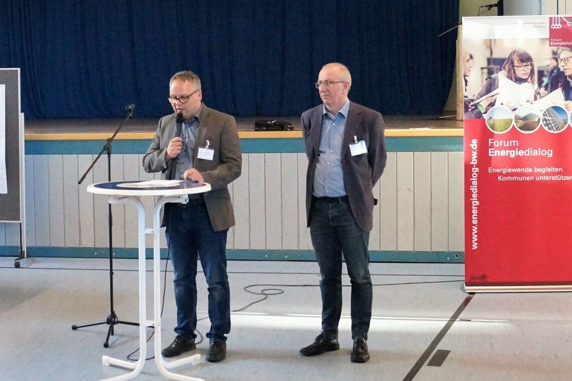 Bürgermeister Reinhold Teufel (am Mikro) und der Konfliktberater Christoph Ewen eröffnen die Diskussion zum Infomarkt Windenergie Pfronstetten.