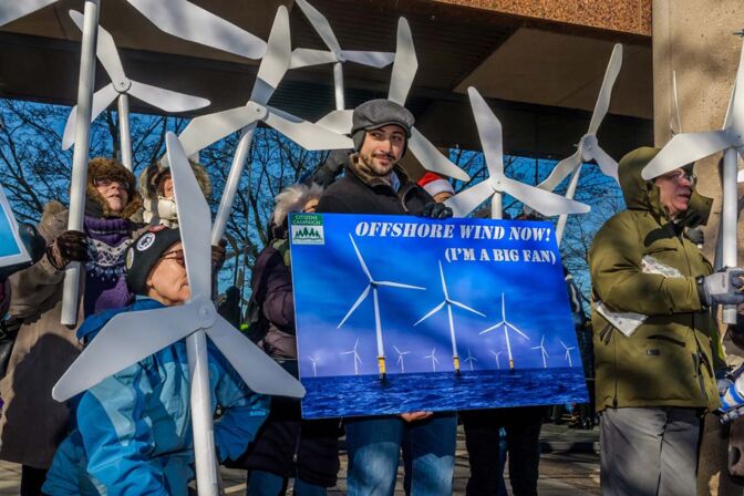 Offshore-Wind in den USA: Demonstranten werben mit Plakaten und Windrädern für den Ausbau der Technologie.