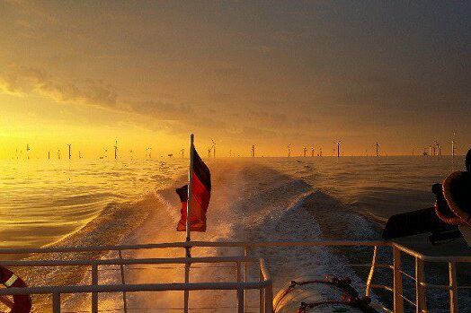 Sonnenuntergang über einem Windpark bei Helgoland: Jannes Piepgras bringt mit Techniker von der Insel zu den Windrädern und zurück.