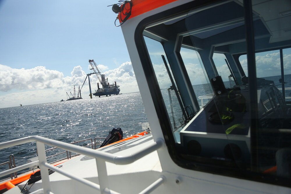 Offshore-Windpark Baltic 2: Mithilfe eines Kranschiffs werden Rotorblätter am Turm eines Windrads angebracht.