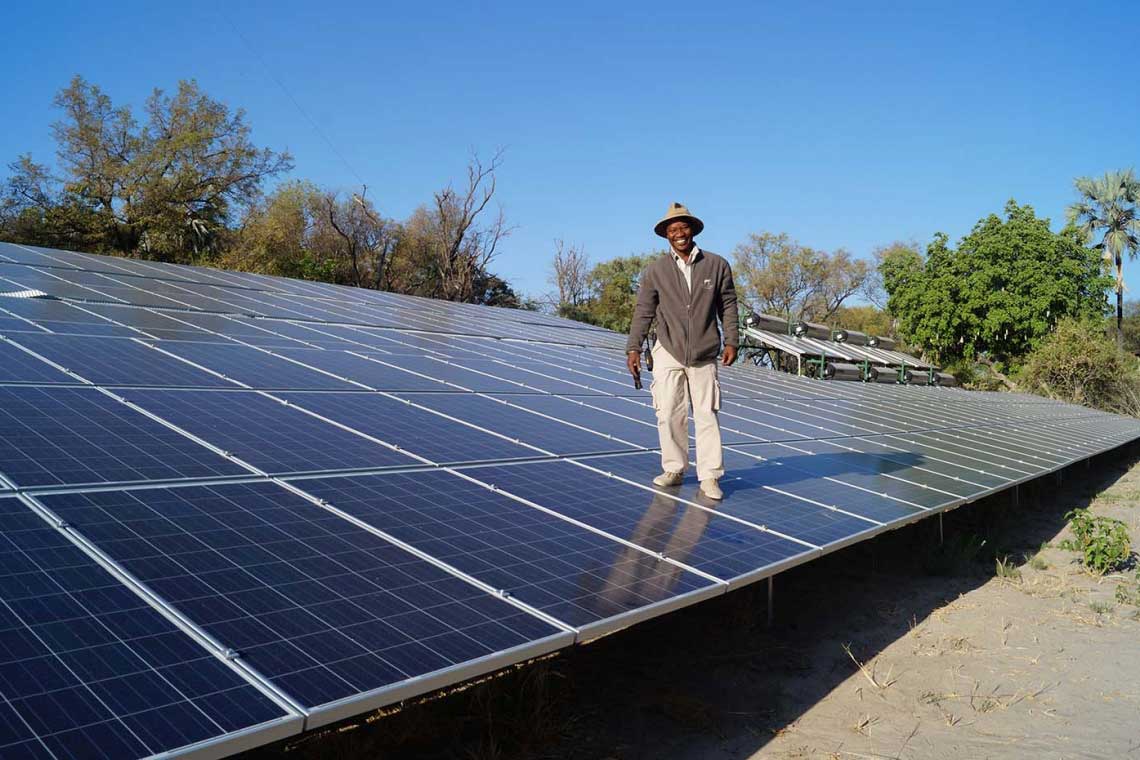 Das Chitabe-Camp versorgt sich mit Solarenergie. Camp-Leiter Thompson Seboni demonstriert die Robustheit der Anlage.