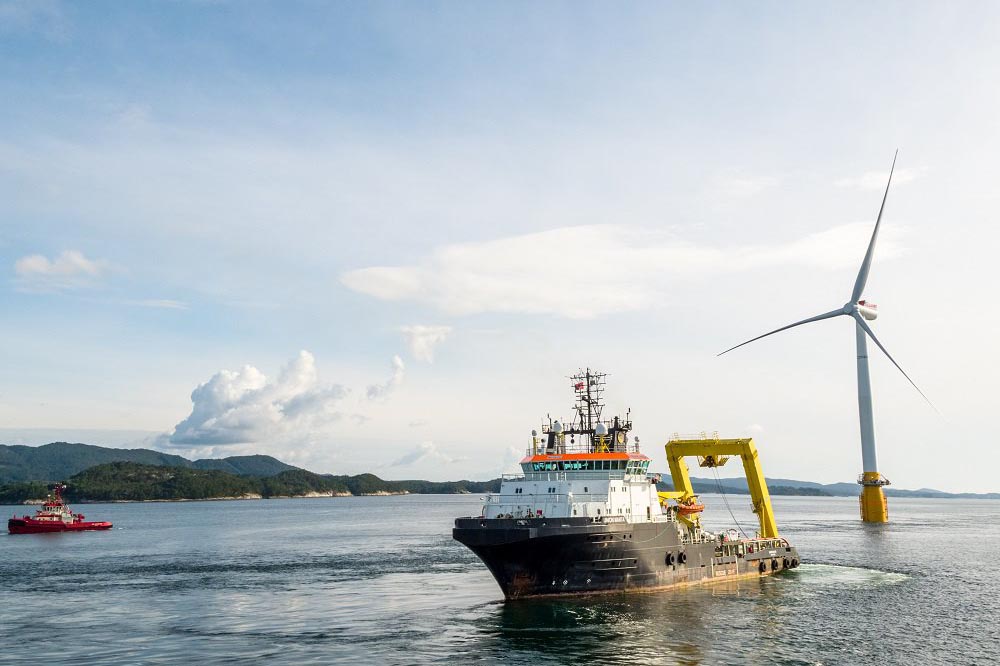 Floating Wind: Eines der Windräder von Hywind wird von Norwegen stehend von einem Schiff nach Schottland gezogen.