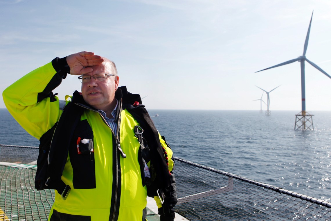 Peter Altmaier besucht den Offshore-Windpark Alpha Ventus und trägt einen Überlebensanzug.