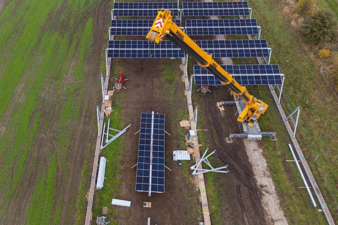 Bau einer Agri-PV-Anlage im Wendland. Unter den hoch über dem Boden hängenden Modulen ist Landwirtschaft möglich.